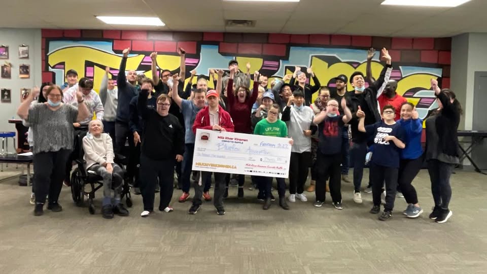 Milk River Kinsmen volunteers present a novelty cheque from the Corvette Raffle to a community group